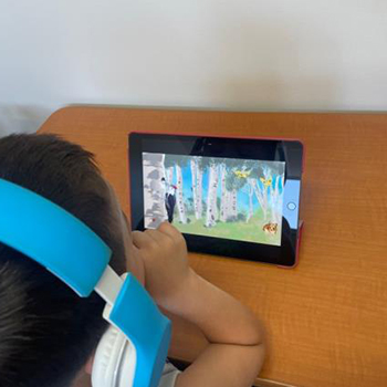 A child wearing headphones looking at a tablet